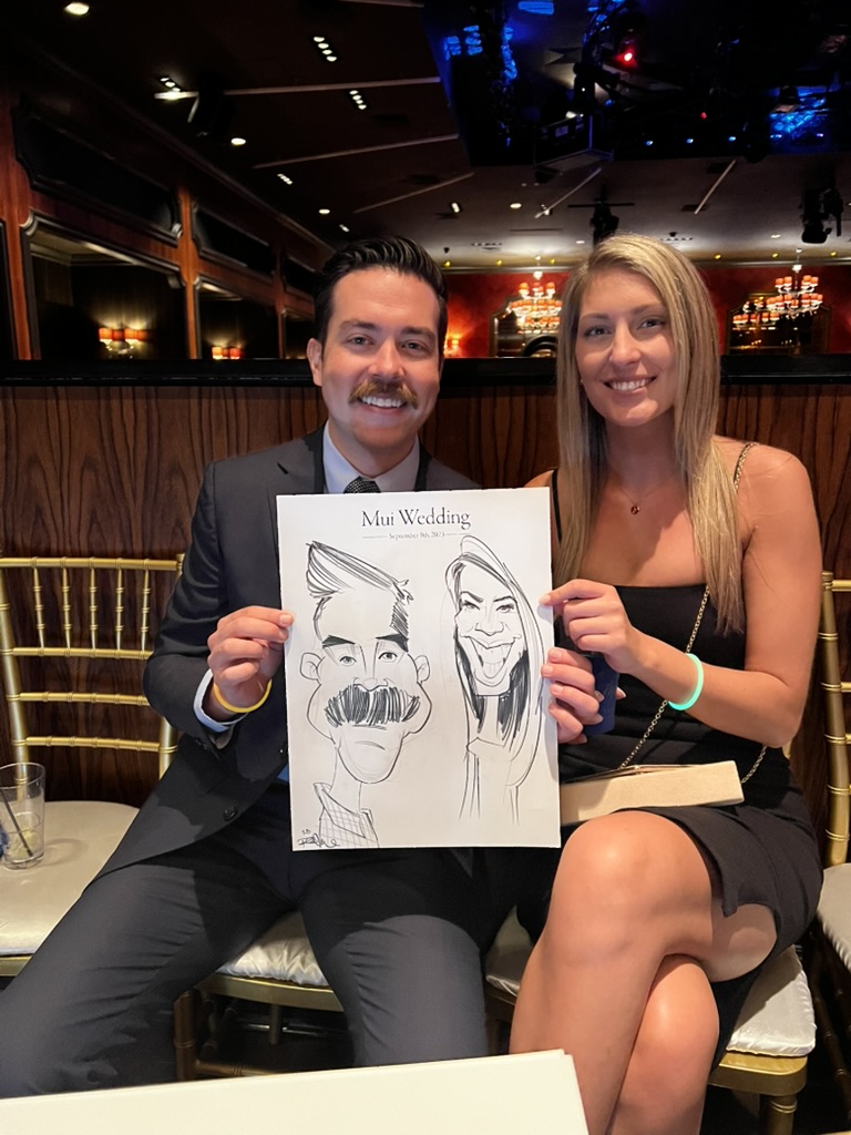 Wedding guests smile while holding their live black-and-white caricature